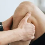 Sports therapy practitioner assessing and treating an adult client