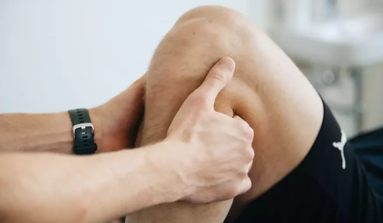 Sports therapy practitioner assessing and treating an adult client
